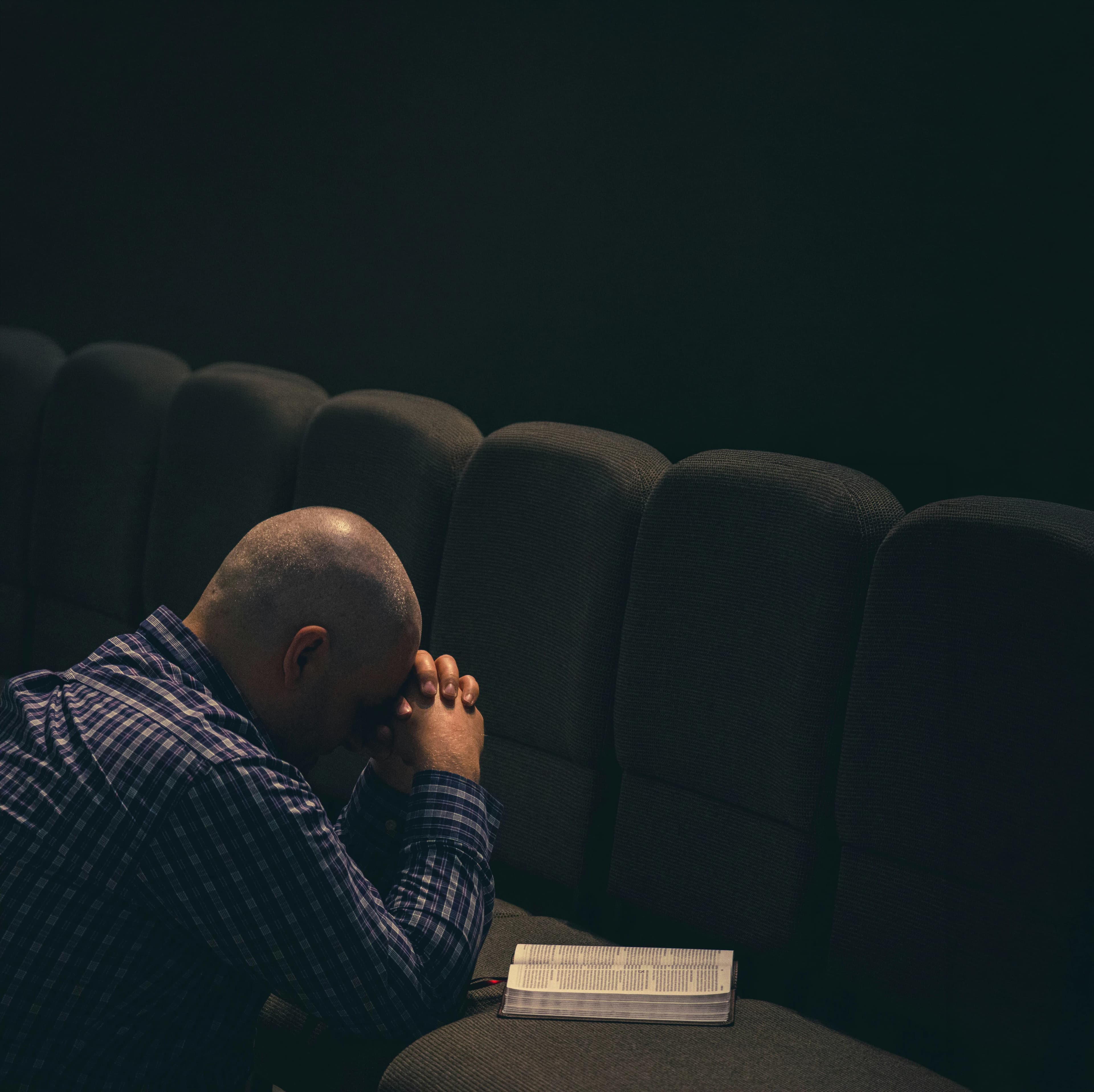 Man praying in church pew